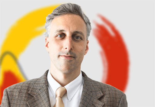 Enzo Sauma frente a logotipo rojo y amarillo