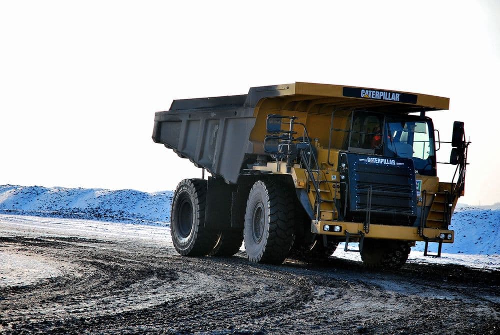 Gran camión de minería transitando camino con barro